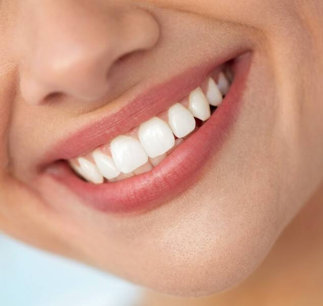 Close up of person smiling with flawless straight white teeth